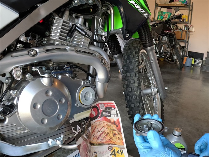 Oil filter cover with O-ring and spring in place - KLX140L