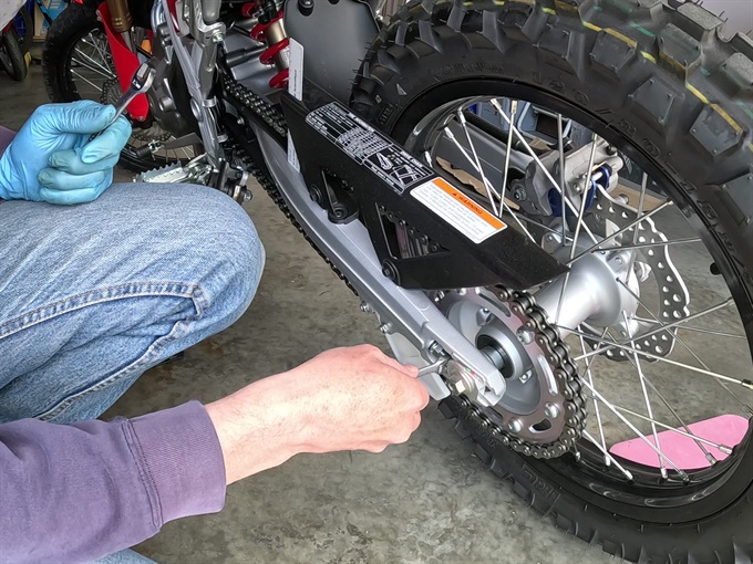 Turning chain adjuster bolt on CRF300L