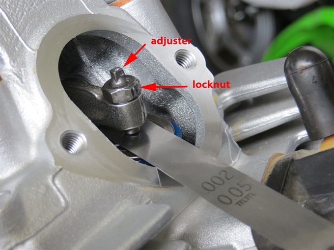 Measuring valve clearance (intake). Red arrow = adjuster, green arrow = locknut - KLX140