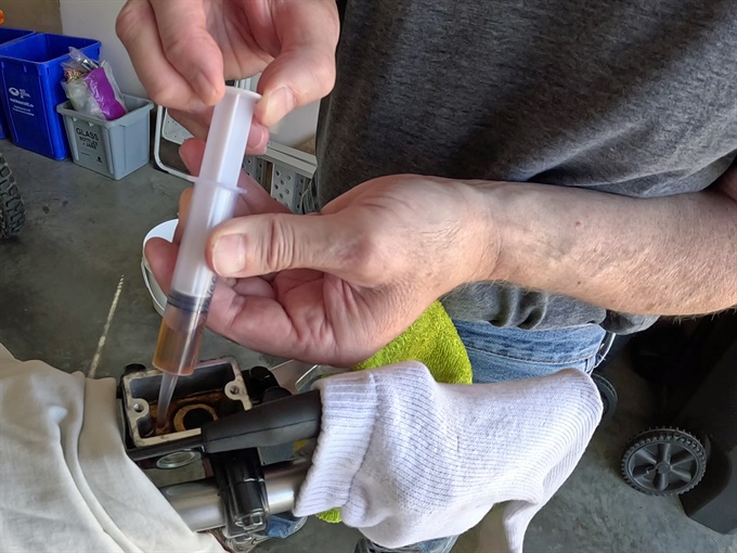 KLX140 - removing old brake fluid from the front master cylinder with a syringe.