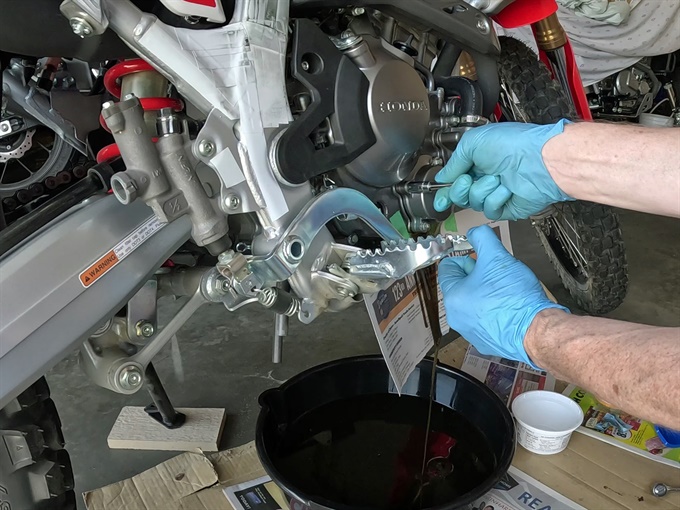 Removing the oil filter cover bolts, 2023 Honda CRF300L