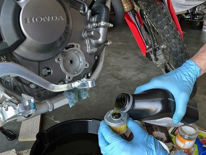 Pouring oil into the new oil filter, 2023 Honda CRF300L