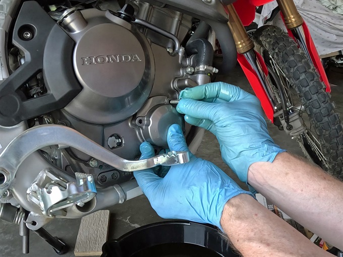 Installing the oil filter cover bolts, 2023 Honda CRF300L